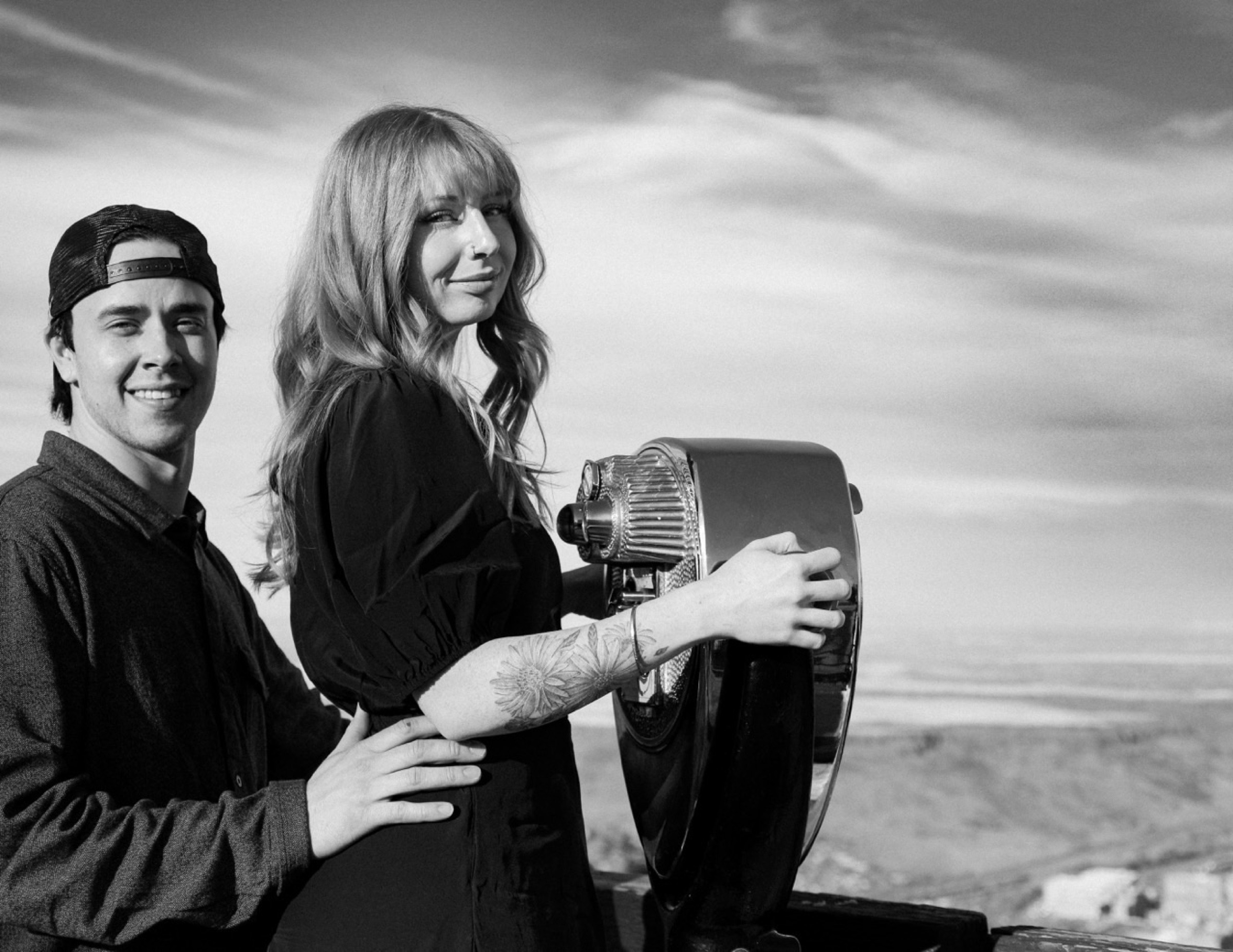 Couple at viewpoint binoculars, black and white